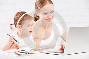 Happy family mother and child baby at home working on computer
