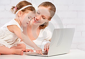 Happy family mother and child baby at home working on computer