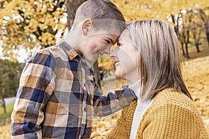 Happy family mother and child boy in the autumn leaf fall in park