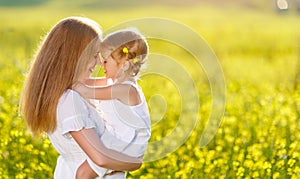 Happy family mother and child daughter embrace on nature in sum photo