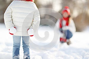 happy family mother and child daughter having fun, playing snowballs at winter walk