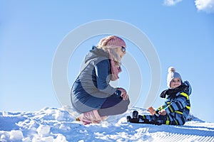 Happy family mother and child daughter having fun, playing at winter walk outdoors