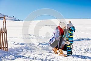 Happy family mother and child daughter having fun, playing at winter walk outdoors