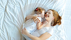 Happy family mother and child daughter laugh in bed