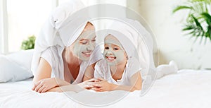 Happy family mother and child daughter make face skin mask