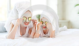 Happy family mother and child daughter make face skin mask