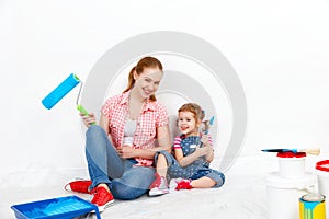 Happy family mother and child daughter making repairs, paint wal
