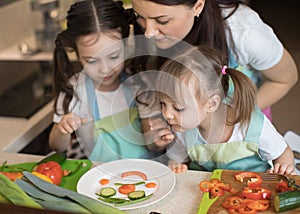 Happy family mother and child girl are preparing healthy food, they improvise together in the kitchen