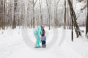 Happy family. Mother and child girl on a winter walk in nature.