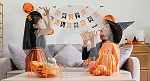 Happy family mother and child happy girl with Halloween at home together beautifully decorated. pretending to release
