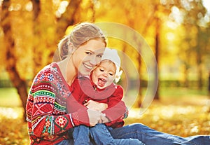 Happy family: mother and child little daughter play cuddling on