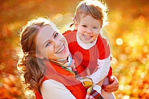 Happy family: mother and child little daughter play cuddling on