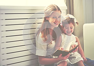 Happy family mother child little girl reading book