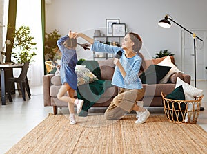 Happy family mother and child play at home and sing with combs photo