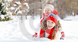 Happy family mother and child playing on winter walk