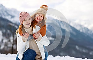 Happy family mother and child playing on winter walk