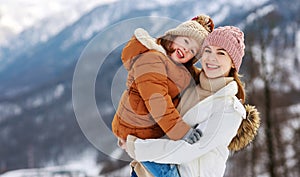 Happy family mother and child playing on winter walk