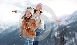 Happy family mother and child playing on winter walk