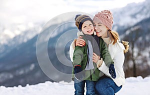 Happy family mother and child playing on winter walk