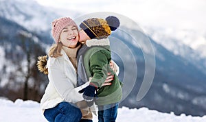 Happy family mother and child playing on winter walk