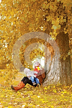 Happy family, mother and child walking in autumn season