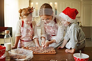 Happy family mother and children bake christmas cookies