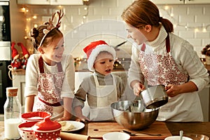 Happy family mother and children bake christmas cookies