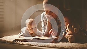 Happy family mother and children read a book in evening