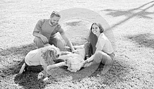 happy family of mother dad and child son playing with pet dog in summer park green grass, adoption