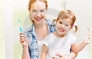 happy family mother and daughter child brushing her teeth toothbrushes