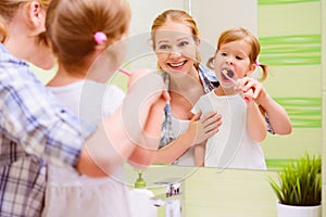 happy family mother and daughter child brushing her teeth toothbrushes