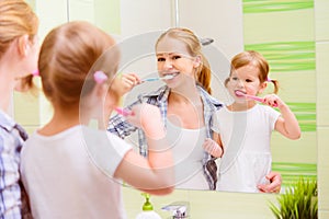 happy family mother and daughter child brushing her teeth toothbrushes