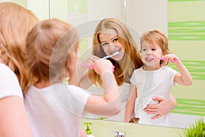 happy family mother and daughter child brushing her teeth toothbrushes