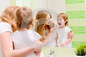 happy family mother and daughter child brushing her teeth toothbrushes