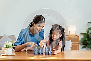 Happy family. Mother and daughter drawing together. Adult woman helping to child girl