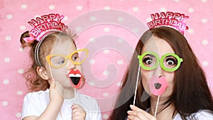 Happy Family - Mother and daughter dress glasses and lips and different decorations to celebrate the birthday. The