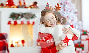 Happy family mother and daughter giving christmas gift