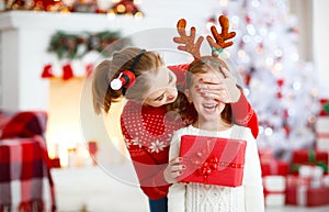 Happy family mother and daughter giving christmas gift