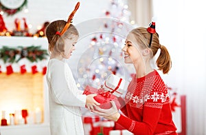 Happy family mother and daughter giving christmas gift