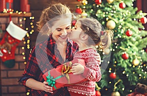 Happy family mother and daughter giving christmas gift