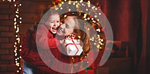 Happy family mother and daughter giving christmas gift