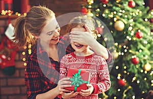 Happy family mother and daughter giving christmas gift