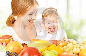 happy family mother and daughter little girl, eat healthy vegetarian food, fruit