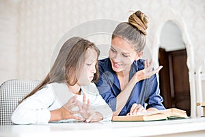 Happy family mother and daughter read a book in the evening at home. the concept of family comfort and family relations