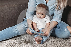 Happy family mother and daughter read a book in the evening at home sitting on the floor