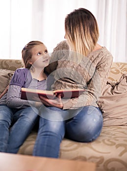 Happy family,mother and daughter read a book at home