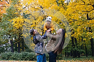 Happy family outdoors. Mother, father and baby on autumn walk in the park