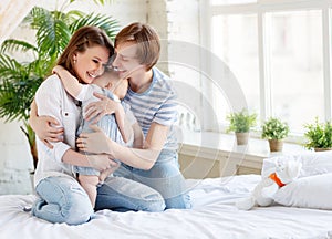 Happy family mother father and baby in bed