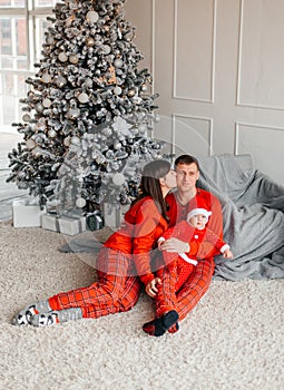 happy family mother father and baby at christmas tree at home