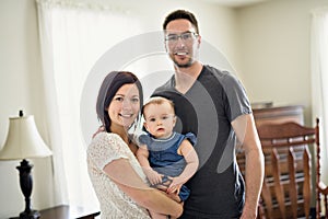 Happy family mother, father and baby at home in bed